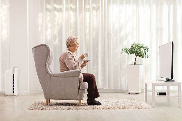 Happy senior lady watching TV Happy senior lady watching TV