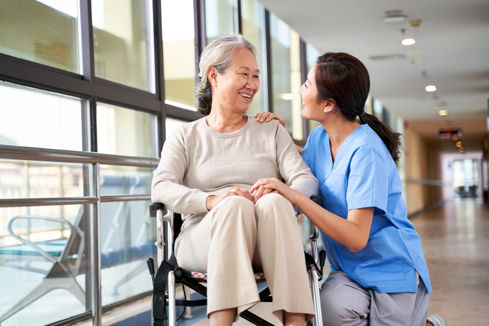 Friendly,Staff,Caregiver,Of,Nursing,Home,Talking,To,Asian,Senior