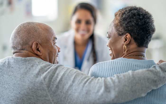 A couple smiling at each other with a caregiver
