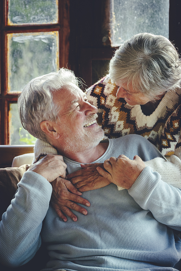 Happy Senior Couple Hug And Enjoy Time Together At Home Sitting