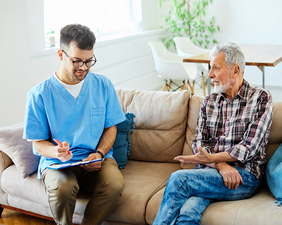 Doctor Or Nurse Caregiver Talking With Senior Man With Chest Pain Doctor Or Nurse Caregiver Talking With Senior Man With Chest Pain
