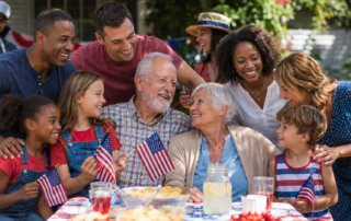 An image of a group of family and friends around a picnic table holding US flags