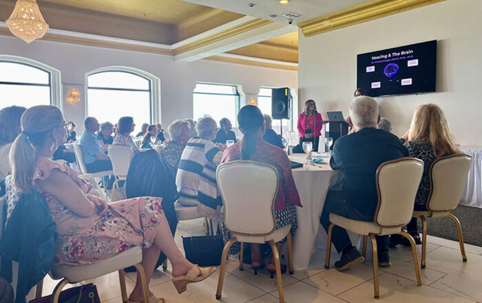 People sitting around tables watching a presentation