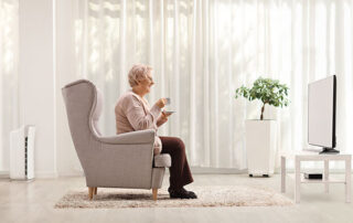 Happy senior lady watching TV