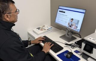 Photo of Shaq sitting at his desk working at his computer.